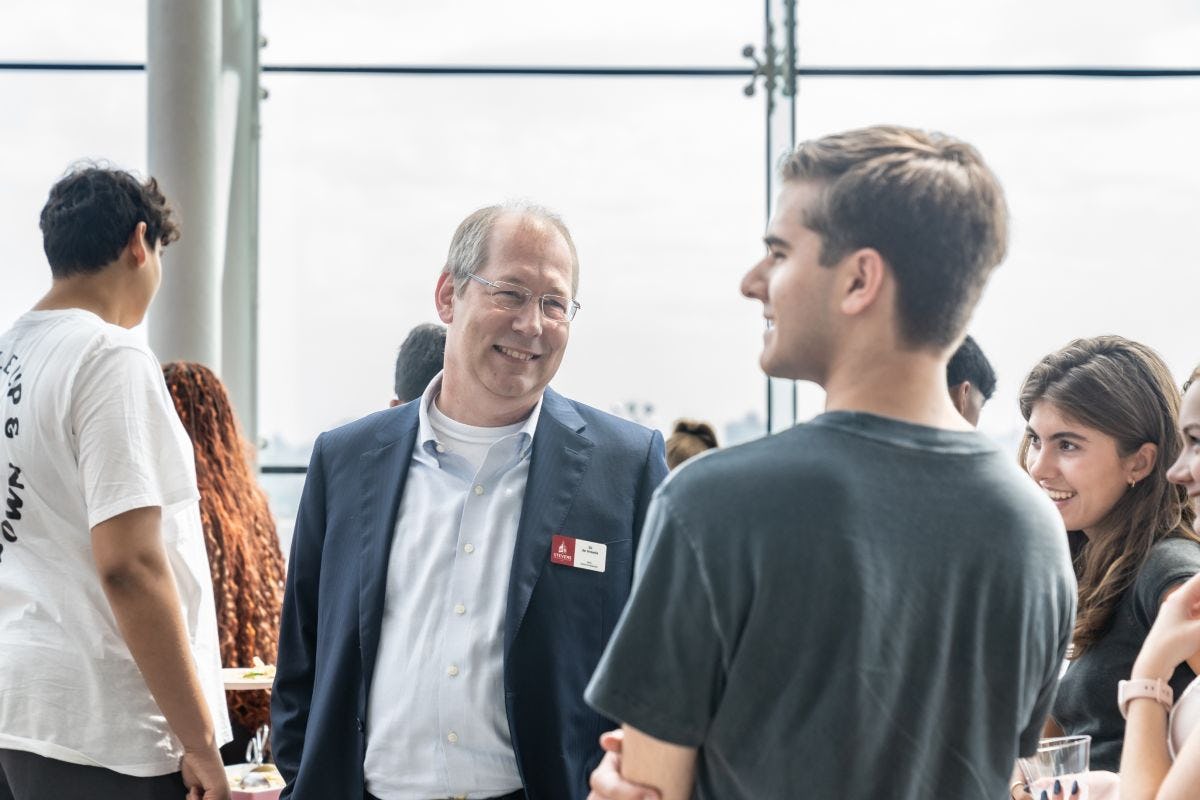 GJ de Vreede speaks with students in the Babbio Center atrium.