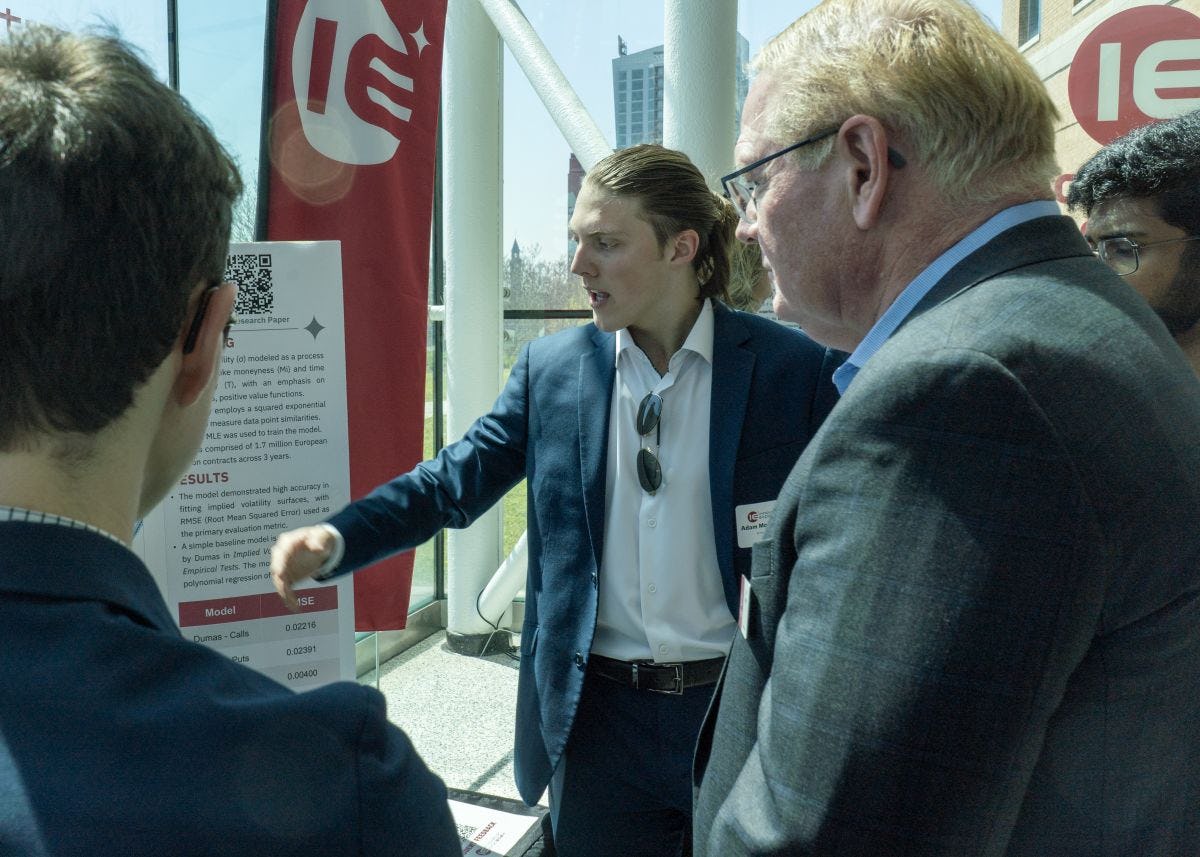 Jeff Hedrick listens to a student give a presentation at the Innovation Expo