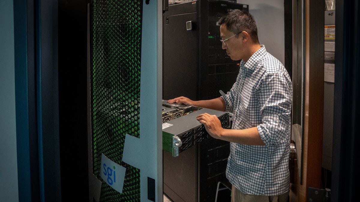 Systems Administrator Zheng Xing examines new Nvidia H100 GPU server from Supermicro 