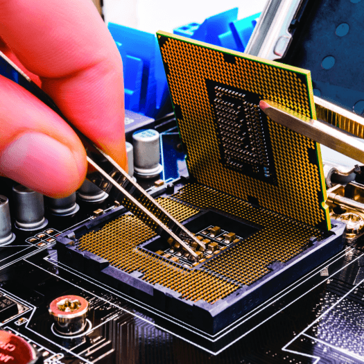 A photo of a thumb and pointer finger holding tweezers, which are tinkering with a computer chip