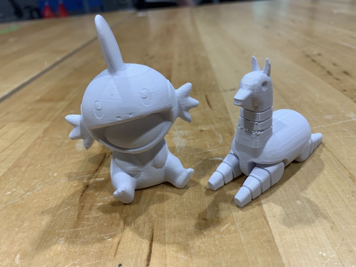 Two white figurines of imaginary creatures