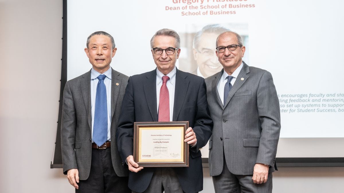 Gregory Prastacos holds his award flanked by Jianmin Qu on the left and Naramin Farvardin on the right.