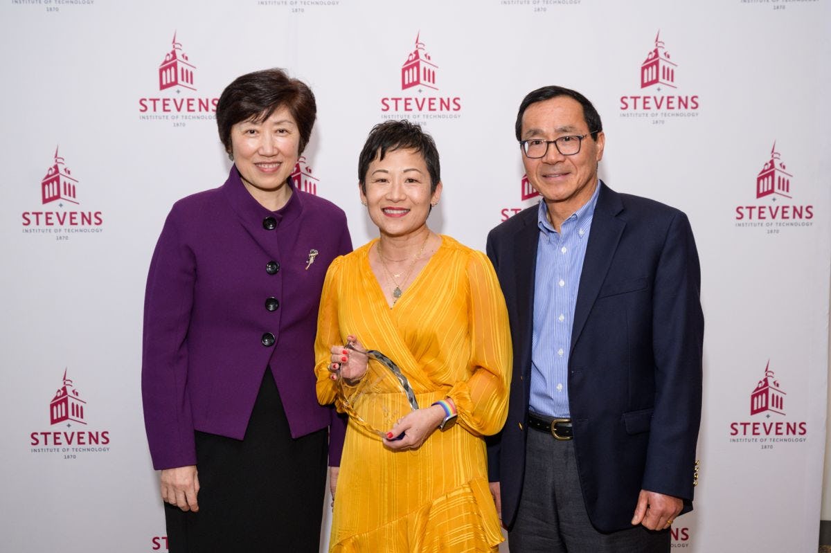 Jean Zu, Jennifer Kang-Mieler and Henry Du standing in front of a Stevens-branded backdrop