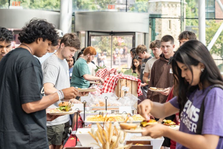 Students go through a line getting food in the Babbio Center atrium.