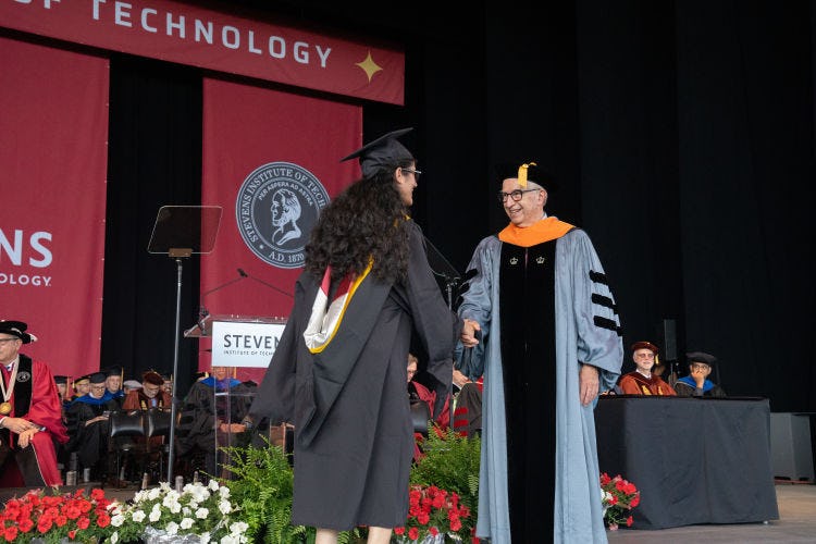 Dean Gregory Prastacos shakes the hand of a graduate to congratulate her
