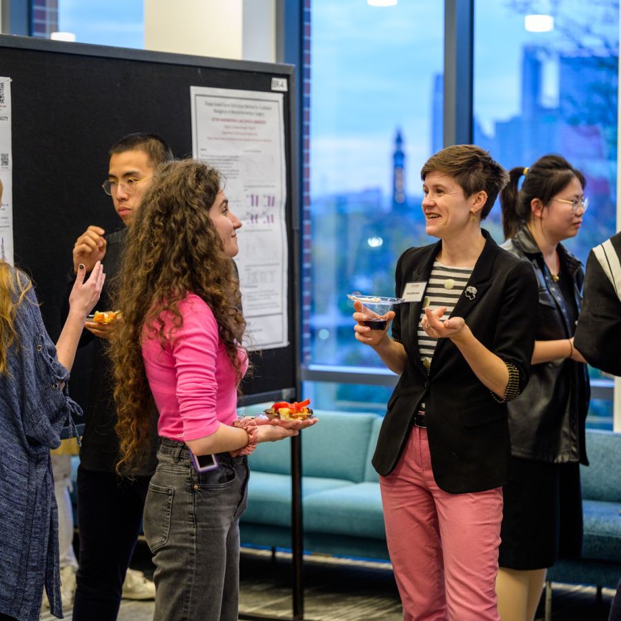 Two students in discussion during a social event and poster sessions at Stevens Institute of Technology.