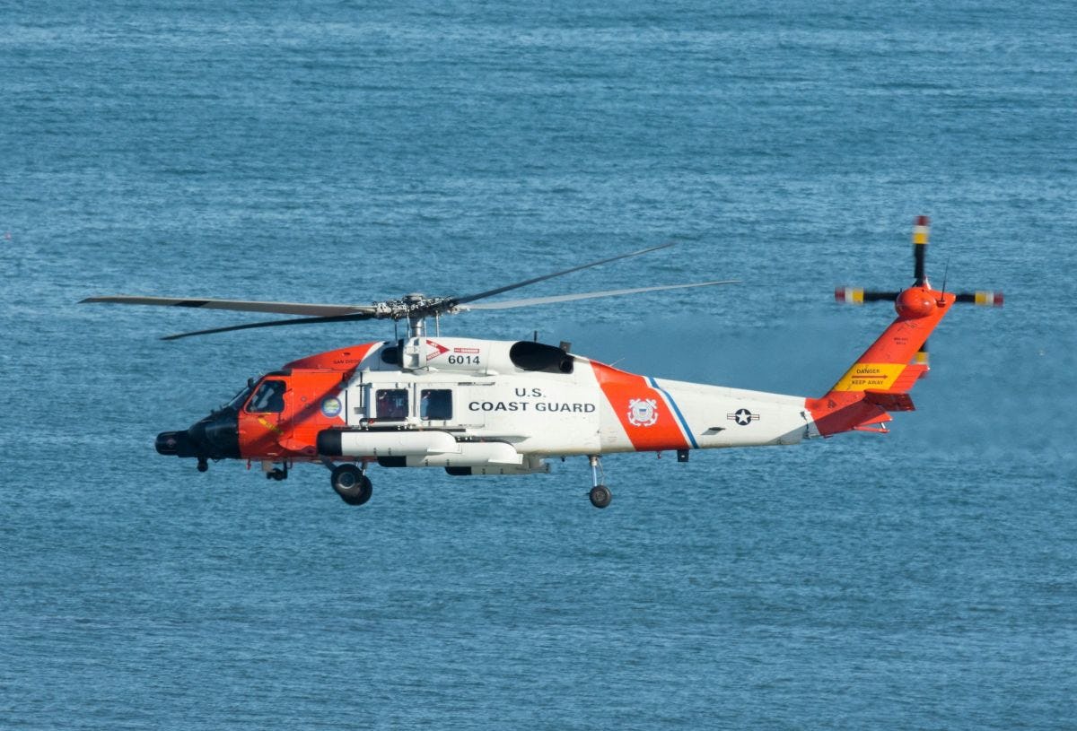 a U.S. Coast Guard helicopter hovering over the ocean
